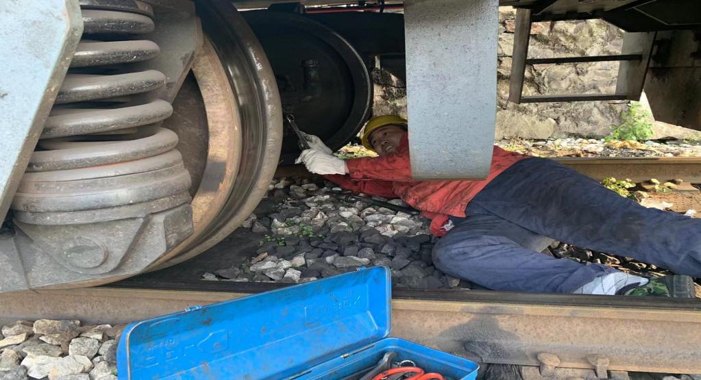 吳雪正在軌道車周圍巡檢排查故障.jpg 吳雪正在軌道車周圍巡檢排查故障.jpg